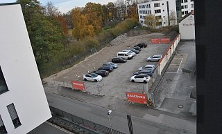 Links der von Gleis-13-Investoren provisorisch geschotterte und schon genutzte Parkplatz, rechts ein Teil des großen Güth-Areals mit Parkplätzen und Altgebäuden. - Ludger Osterkamp