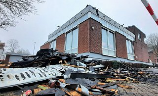 Das abgerissene und verkohlte Flachdach liegt am Morgen nach dem Brand auf dem Parkplatz vor der Sparkasse Nieheim. - David Schellenberg