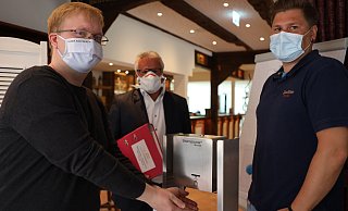 Hygiene-Experte Michael Großkurth (Mitte) mit Geschäftsführer Vitus Schulte (l). und Gastronomieleiter Andreas Bünz an dem Desinfektionsspender im Eingang des Weinhauses Möhle. - Jörg Stuke