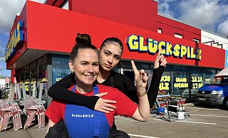 Die mürrische Leonie sitzt huckepack auf dem Rücken von Steffi - beide sind die Gesichter der Burger-Kette Glückspilz, die nun auch in der Kurstadt eröffnet. - Nicole Sielermann