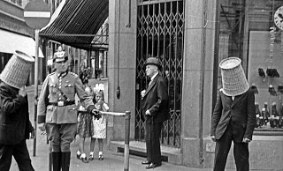 Mit rätselhaften Körben auf dem Kopf gehen Männer über den Neuen Markt. - Meinhard Fenske (Kommunalarchiv)