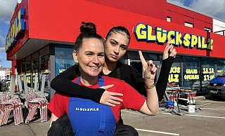 Die mürrische Leonie sitzt huckepack auf dem Rücken von Steffi - beide sind die Gesichter der Burger-Kette Glückspilz, die nun auch in der Kurstadt eröffnet. - Nicole Sielermann