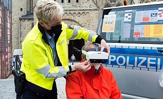 Verkehrssicherheitsberaterin Ingrid Sandbote zeigt Radfahrer Franz Kudak, wie die VR-Brille aufzusetzen ist. - Lena Henning