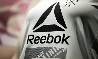 Das Reebok-Logo auf einem Shirt. (Archivbild) - Daniel Karmann/dpa