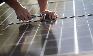 Mitarbeiter einer Firma montieren Photovoltaikmodule auf dem Dach eines Wohnhauses. - Marijan Murat/dpa