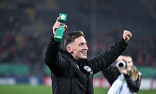 Arminia Bielefelds Marius Wörl feiert den Pokal-Triumph mit der „Player of the match“-Trophäe. - Teresa. Kroeger