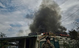 Ein ukrainischer Soldat geht an einem Haus vorbei, das nach einem Beschuss in der Nähe der Frontlinie abgebrannt ist. Russland führt seit Februar 2022 Krieg gegen die Ukraine. - LIBKOS/AP/dpa