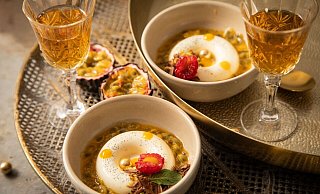 Panna Cotta mit Passionsfrucht, Himbeere, Mangotupfer, Minze, Pistazie, Schokolade und goldenen Schokokugeln in Savarin-Form zubereitet. Das ist eine Backform in flacher, ringförmiger Gestalt. - Christin Klose/dpa-tmn