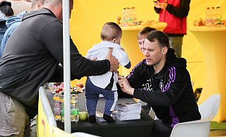 Torwart Manuel Neuer (r.) und Maximilian Beier geben Autogramme. Neuer unterschreibt hier auf einem Baby-Trikot. - Christian Charisius/dpa