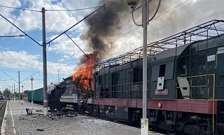 Auf diesem von der Pressestelle der ukrainischen Eisenbahn zur Verfügung gestellten Foto geht ein Personenzug nach einem russischen Drohnenangriff auf einen Bahnhof in Schostka in der Region Sumy in Flammen auf. - Uncredited/Ukrainian Railway Press Office via AP/dpa
