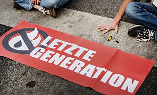 Ein Aktivist der Letzten Generation klebt seine Hand auf einer Straße fest. Solche Klebeaktionen hat die Gruppe inzwischen aufgegeben - und nun eine Kandidatur für das Europaparlament angekündigt (Archivbild). - Swen Pförtner/dpa