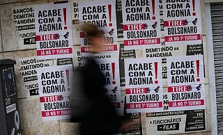 Eine Frau geht in Rio De Janeiro an Schildern vorbei, auf denen auf portugiesisch zu lesen ist: «Schluss mit der Agonie, Bolsonaro raus». - Matias Delacroix/AP/dpa