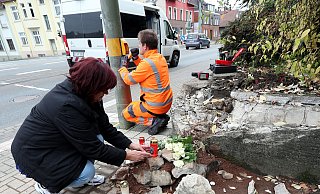 Eine Anwohnerin platziert eine Kerze an der Unfallstelle. - Wolfgang Rudolf