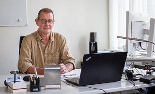 Claus Josephs sitzt an seinem Schreibtisch mit Blick auf den Franz-Stock-Platz. - Niklas Tüns