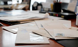 Ungeöffnete Briefe liegen auf einem Schreibtisch. | Verwendung weltweit - picture-alliance / Frank May (Symbolbild)