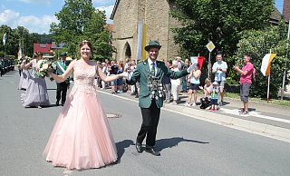 Das Kollerbecker Königspaar Torben Rheker und Lena Thomas führt den Festumzug an der Kirche vorbei, wo das Publikum schon gespannt auf die Königsparade wartet. - Burkhard Battran