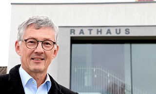 Bernd Dumcke steht vor dem Spenger Rathaus und könnte sich sehr gut vorstellen, auch in der nächsten Wahlperiode dort als Bürgermeister ein- und auszugehen. - Andreas Sundermeier