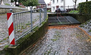 Der Rechenfang neben der Kirche, der verhindert, dass Treibgut in die Kanalisation gerät, kann bei Starregen zur Sperre werden, die die Überschwemmungsgefahr weiter verstärkt. - Burkhard Battran