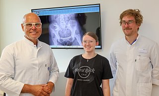 Freuen sich über die vollständige Genesung: Dieter Mann, Chefarzt der Klinik für Unfallchirurgie und Leiter des Regionalen Traumazentrums (v.l.), Patientin Emily Meyer und Oberarzt Johannes Dreischalück. - St.-Elisabeth-Hospital