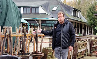 Thorsten Fleer steht vor der Moor-Ranch und zeigt auf die Stühle, die in der Witterung arg gelitten haben. - Andreas Sundermeier