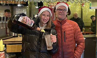 Greta Castelle und Standbesitzer Ralf Heming sind großzügig beim Ausschenken auf dem Paderborner Weihnachtsmarkt. - Jule Prietzel