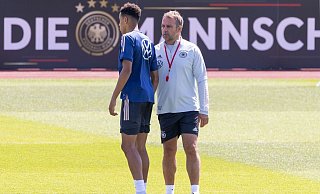 Bundestrainer Hansi Flick (r) spricht während des Trainings der deutschen Nationalmannschaft mit Jamal Musiala. - Foto: Daniel Karmann/dpa