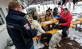 Ein Mitarbeiter des Ordnungsamtes (l.) kontrolliert die Impfzertifikate von Gästen einer Skihütte am Skilift Rauher Busch in Winterberg. - picture alliance/dpa