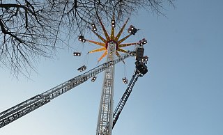 21 Fahrgäste des Kettenkarussells müssen in luftiger Höhe etwa eine Stunde ausharren, bevor die Feuerwehr sie befreien kann. Der Korb der Drehleiter muss 22 Meter ausfahren, um die Fahrgäste zu erreichen. - Ekkehard Hufendiek
