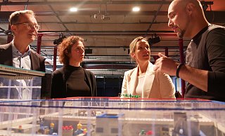 Günter Korder (v. l.), Rebecca Steinhage, Kirsten Thommes und Roman Dumitrescu sprechen über den KI-Einsatz in OWL über einem Modell, das Einsatzmöglichkeiten zeigt. - Jemima Wittig