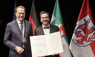 Der Düsseldorfer Oberbürgermeister Stephan Keller )l) überreicht Juri Andruchowytch die Urkunde seiner Auszeichnung. - David Young/dpa