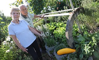 Ursula Haase und Michael Harmann an dem Hochbeet, wo viele verschiedene Kräuterarten für die Küche wachsen - und mittendrin der Salat dazu. - Simone Flörke