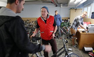 Das passt: Adalbert Grüner (Mitte) übergibt eines der gespendeten Fahrräder an einen jungen Flüchtling. Lukas Grüner (hinten, r.) kümmert sich um die Registrierung. Auf dem Fahrrad sind zwei Aufkleber angebracht: einer vom Verein Non Stop Ultra und einer von der Flüchtlingshilfe. - SIMONE FLÖRKE