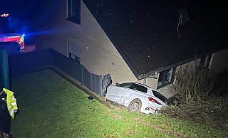 Das Auto ist zwischen Hang und Hauswand eingeklemmt. Die Bergung ist aufwendig. - Polizei Paderborn