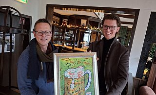 Christoph (l.) und Jan Nobbe mit einem Bild, das ein Gast im Dezember 2023 zur Wiedereröffnung mitbrachte. Sämtliche Gäste haben seinerzeit darauf unterschrieben. - Meiko Haselhorst