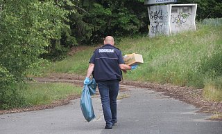 Ein Mitarbeiter des Bünder Ordnungsamts trägt einen blauen Sack und einen Karton voller Papiere aus dem alten Kurhaus im Ortsteil Randringhausen. - Florian Weyand