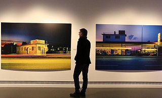 Kurator Markus Runte betrachtet ein Bild der Detmolder Straße aus den 80er Jahren. Daneben ist ein Blick auf eine Tankstelle an der Bahnhofstraße. - Holger Kosbab