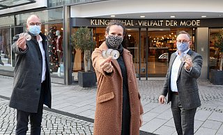 Uwe Seibel (Vorsitzender der Werbegemeinschaft, (v. l.), Carmen Keuper (Marketing Textilhaus Klingenthal) und Daniel Lükel (Geschäftsleiter Textilhaus Klingenthal Paderborn) präsentieren die Weihnachtstaler. - Heiko Appelbaum