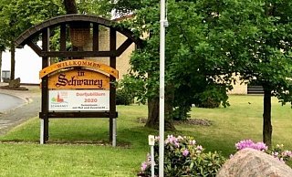 Die Schwaneyer haben die Ortseingangsschilder abgeändert und begrüßen, zusammen mit der neuen Ortsfahne, die Besucher mit der Aufforderung: "Gemeinsam – mit Mut und Zuversicht!" - Heimat- und Vereinsgemeinschaft Schwaney
