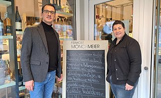 Orhan Savci und Julia Büyükdag stehen neben der Speisekarte, die über die Mittagsgericht bei "Feinkost Mönchmeier" informiert. - Marion Pokorra