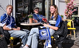 Gemütlich sitzen Bielefeld-Fans vor dem Spiel in der Sonne. - Teresa Kroeger
