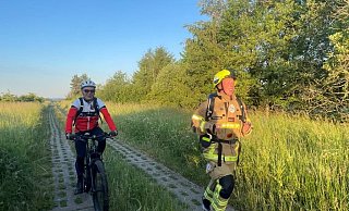 Willi Hoppe begleitet auf dem Rad einen der laufenden Feuerwehrleute beim Feuerwehr Grenzlauf 2022 an der ehemaligen deutsch-deutschen Grenze. - RMC Schloß Neuhaus