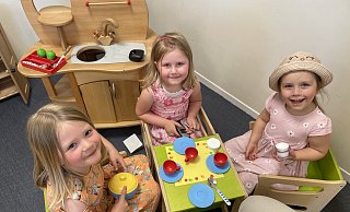 Hanna (5, von links), Mila und Lilli (beide 4) stoßen in der kleinen Kinderküche bei einem "Kaffeeklatsch" auf die neue Kita an. - Natalie Gottwald