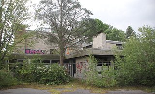 Ein Bauzaun soll das Kurhaus Ernstmeier vor Eindringlingen schützen. Doch zahlreiche Scheiben sind eingeschlagen, die Wände besprüht. - Florian Weyand