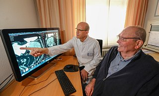 Nach der erfolgreichen OP kann Claus Diekmann wieder strahlen. Auf dem Röntgenbild zeigt Klinikdirektor Jan Schulte am Esch ihm nochmal den 20 Zentimeter großen, bösartigen Tumor, der größer war als die Leber selbst. - Andreas Zobe