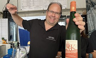 Peter Reichert vom Stand Weinberatung Janine Reichert/Moselwein e.V. zeigt einen Riesling. - Gina Köhler