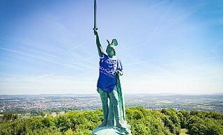 Das Hermannsdenkmal in Detmold hat sein XXXL-Arminia-Trikot wieder abgelegt. Fans können jetzt einen Teil davon ergattern. - Mike-Dennis Müller