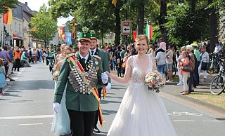 Das amtierende Elsener Schützenkönigspaar Michelle Meier, hier in einem weißen Kleid, und Jan Schlenger freut sich bei der Parade über den Applaus der zahlreichen Besucherinnen und Besucher. - Moritz Jülich