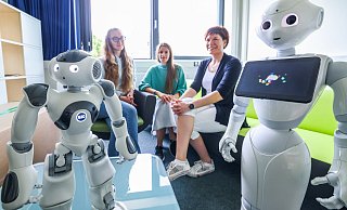 Roboter Nao hat leuchtende Augen, denn neben ihm steht der ebenso faszinierende Pepper. Dass Nao ein Sportler ist und Pepper ein Geschichtenerzähler, das verdanken sie Maria Melnikova, Anna-Lisa Vollmer und Ira-Katharina Petras (v.l.). - Sarah Jonek