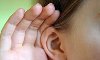 Ein Kind hält die Hand ans Ohr. - Helen Ahmad/picture alliance/dpa