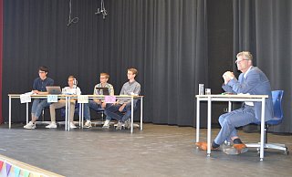 Christian Haase diskutiert mit den Schülern der zehnten Jahrgangstufe der Gesamtschule Brakel über aktuelle politische Themen. Kevin, Liam, Kilian und Lars führen moderierend durch die Fragerunde. - Nicole Niemann
